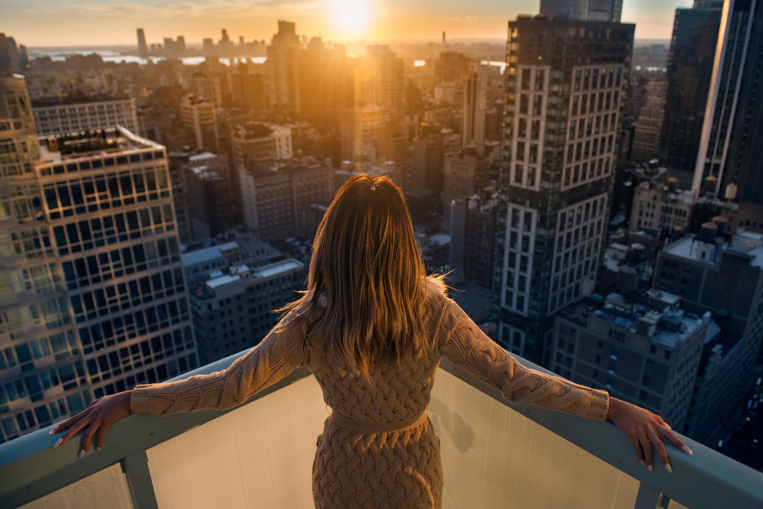 person on balcony looking at skyscrapers