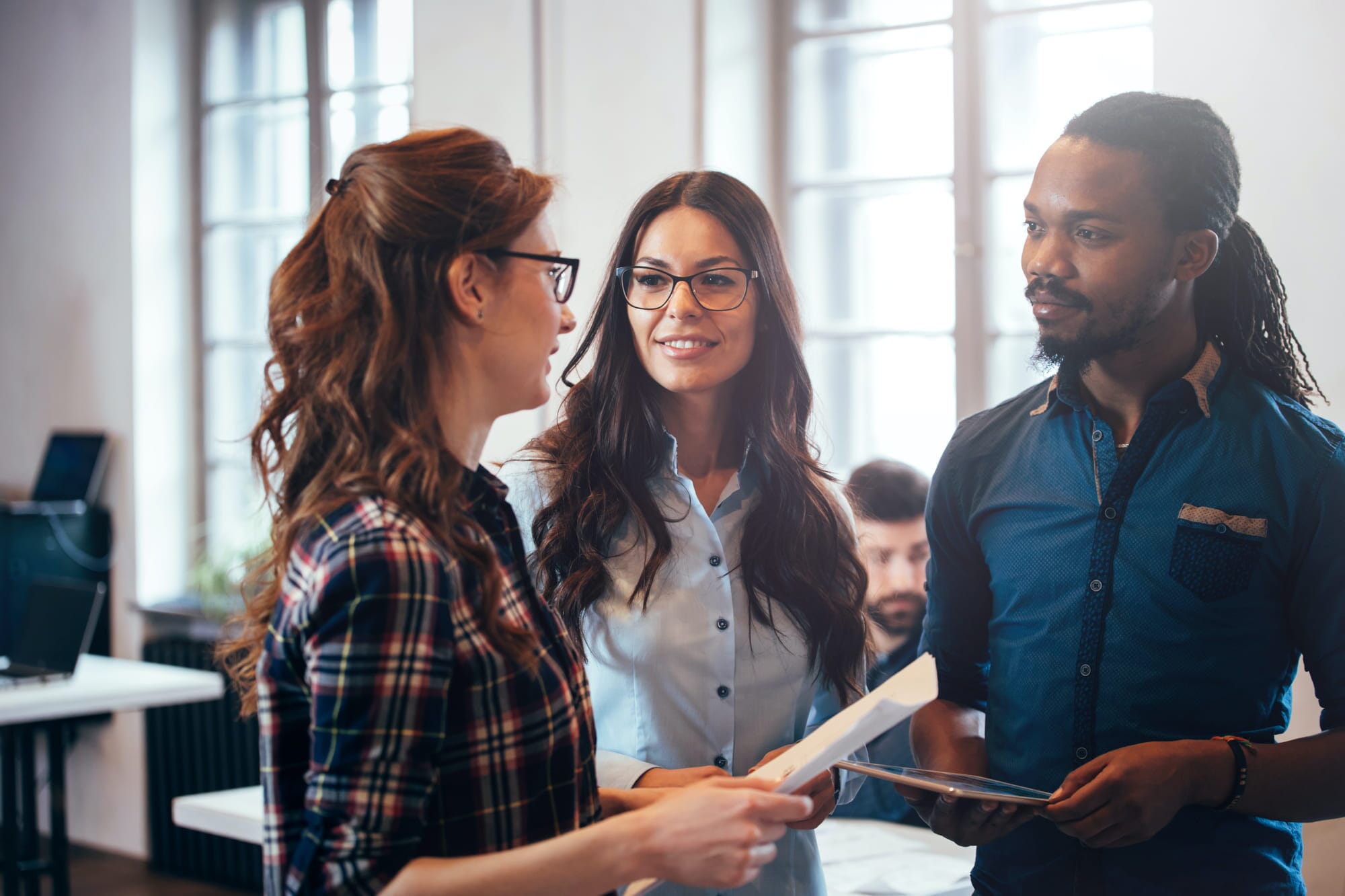 three people talking at work