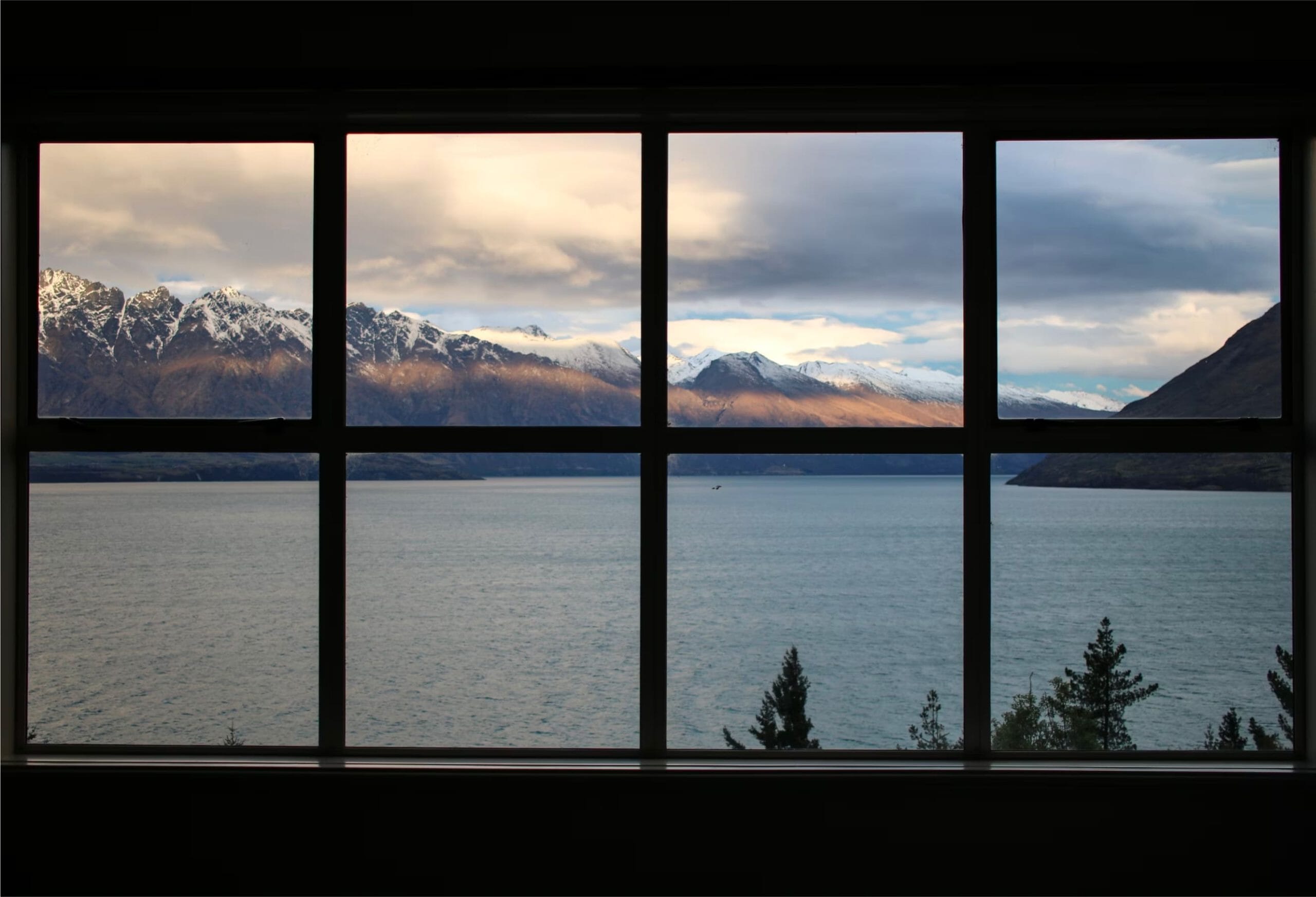 view from a window onto a lake with mountains