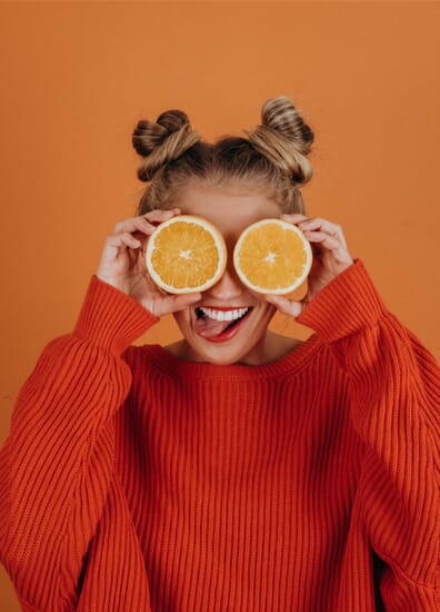 person with oranges over their eyes