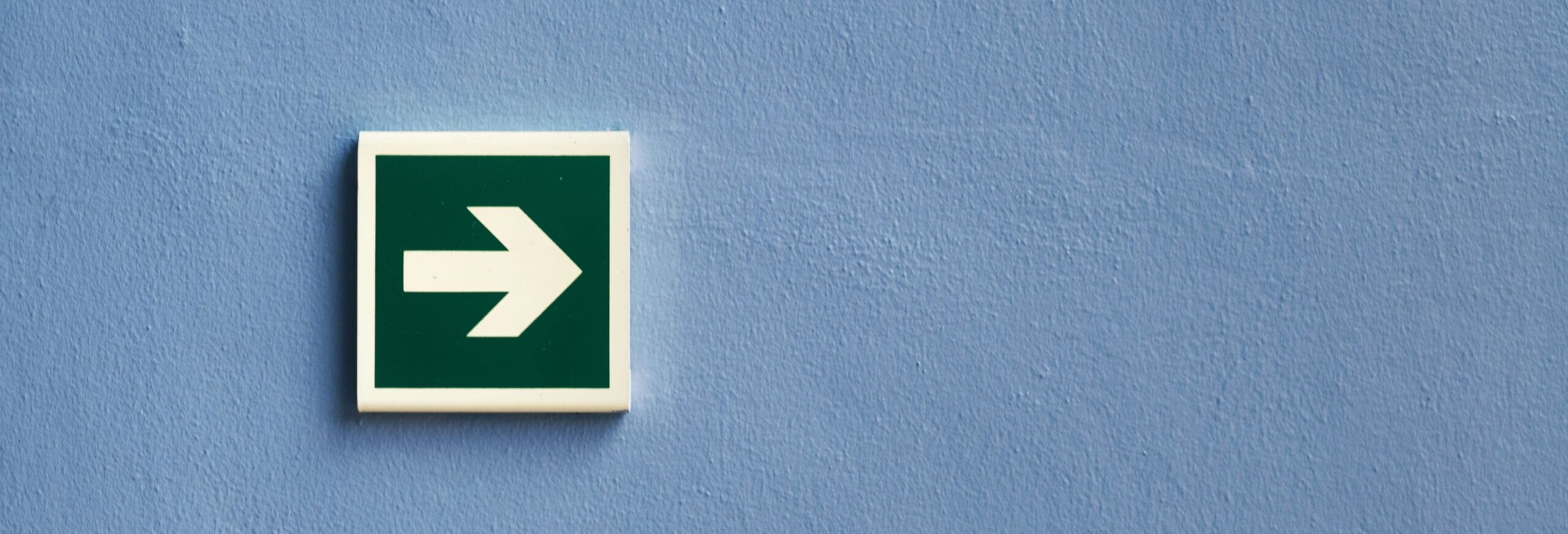 green arrow sign on a wall